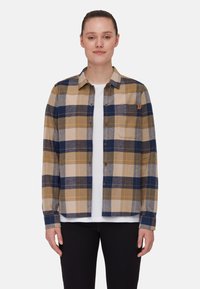 Camicia di flanella con un motivo a quadri giallo, blu e grigio. Presenta una chiusura con bottoni sul davanti, colletto e una tasca sul petto. Texture morbida.