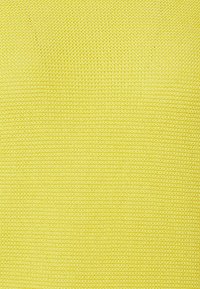 Světlá žlutá texturovaná tkanina s hladkým, tkaným povrchem. Rovnoměrná barva s konzistentním vzorem po celé ploše.