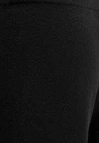 Mustat legginsit, jotka on valmistettu pehmeästä jersey-kankaasta, jossa on sileä pinta ja istuva muotoilu joustavyötäröllä.