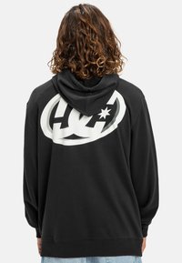 Black hoodie featuring a large white logo on the back, made of soft material with a classic fit and adjustable drawstring hood.