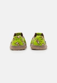 Gröna kanvas slip-on skor med apmönster, bruna accenter och flätade jute-sulor. Slät textur, rund tådesign.