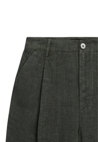 Pantalon plissé vert foncé en tissu léger ; il dispose d'une fermeture à boutons et de poches latérales avec une finition texturée.