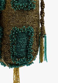 Bolso de cuentas colorido que presenta cuentas doradas y turquesas, patrones intrincados, mango trenzado y borlas de cuentas como acentos decorativos.