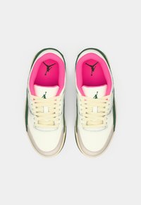 Pár bílých a zelených tenisek s jasně růžovým vnitřním podšíváním a černými logy Jumpman uvnitř, z pohledu shora na bílém pozadí.