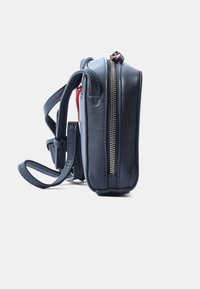 Borsa a spalla in pelle blu navy con dettagli rossi, dotata di una cerniera argento, tracolle regolabili e una forma rettangolare compatta.