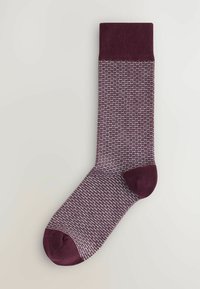 Calcetín burdeos con patrón y diseño texturizado, que presenta un puño y puntera de color sólido. El material parece suave y elástico.