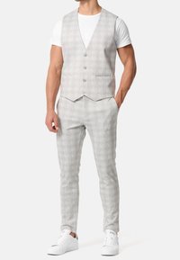 Light gray plaid vest and matching pants with a slim fit. The vest has a v-neck, five buttons, and a single chest pocket. Paired with white sneakers.