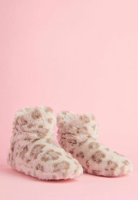 Bota iz umetnega krzna v svetlo bež barvi z leopardskim vzorcem. Opremljene so z nagubanjem, mehko teksturo in zaobljenim prstom za udobje.