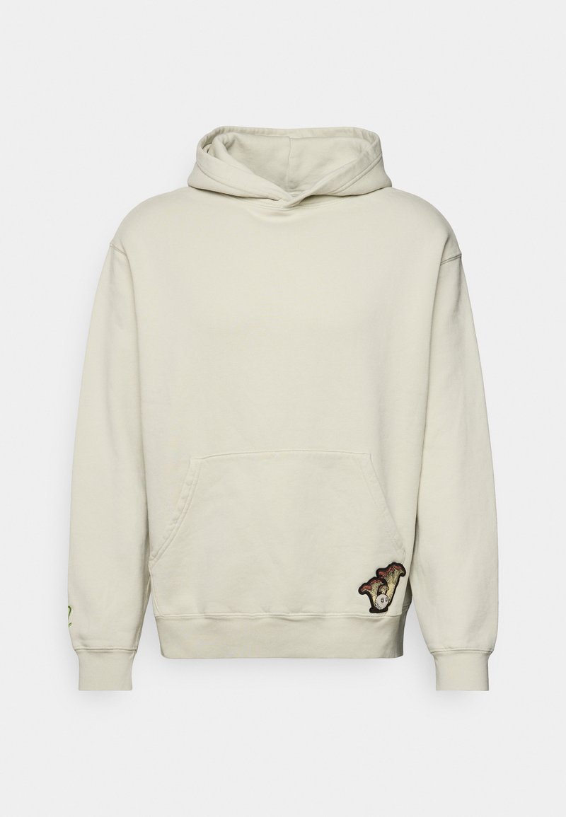 Cream-colored hoodie with a front pocket, drawstring hood, and an embroidered graphic on the lower left. Soft fabric with ribbed cuffs.