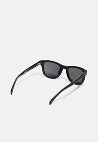 Black sunglasses with a sleek plastic frame and gray lenses. The arms feature a subtle metallic detail, adding texture and contrast.