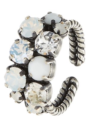 Bague réglable argentée avec bande torsadée, ornée de grosses et petites pierres facettées transparentes et blanc laiteux en sertissages griffés.