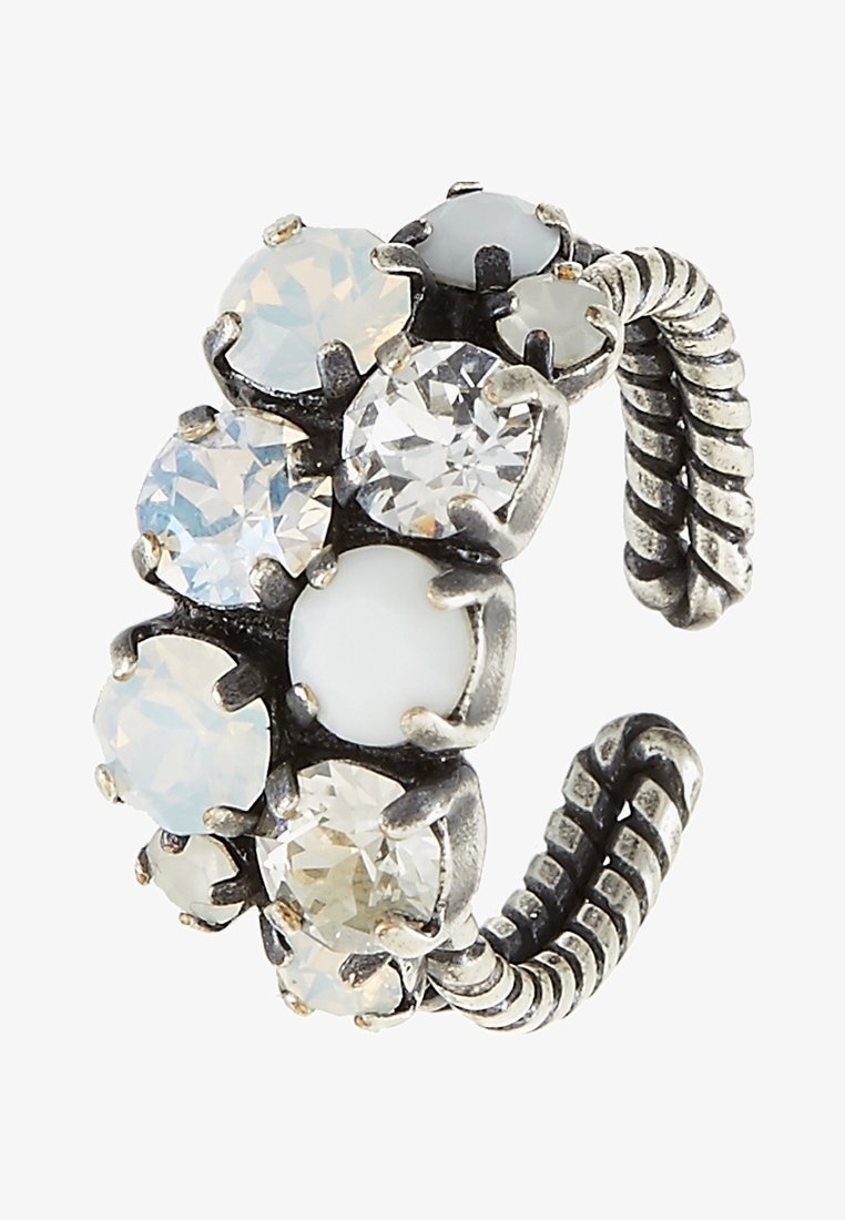 Bague réglable argentée avec bande torsadée, ornée de grosses et petites pierres facettées transparentes et blanc laiteux en sertissages griffés.