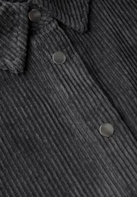 Zwarte corduroy stof met een verticale ribbelstructuur, met een kraag en twee ronde zwarte knopen.