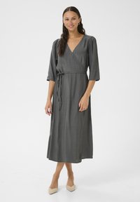 Gray wrap dress with a V-neck, three-quarter sleeves, and a tie waist. Smooth fabric, floor length, and subtle draping detail.