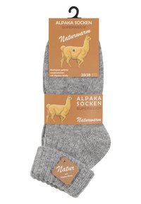 Calze in alpaca grigio, con polsino a coste, etichettate con un'illustrazione di un alpaca e testi che affermano "super morbido" e "naturalmente caldo". Taglia 35/38.