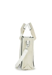 Eine cremefarbene, texturierte Stoffhandtasche mit einem weißen abnehmbaren Riemen und einem Metallverschluss, die auf einem weißen Hintergrund aufrecht steht.