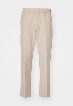Pantaloni bej cu o textură netedă, croială dreaptă și un tiv elastic. Dispun de buzunare laterale și o culoare neutră, potrivită pentru ținute versatile.