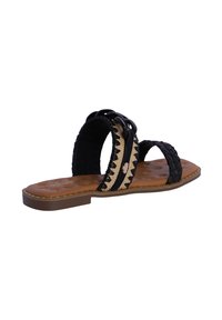 Sandalia deslizante negra tejida con dos tiras, plantilla acolchada color tostado y suela plana marrón. Presenta un detallado decorativo trenzado.