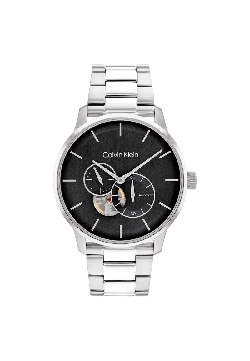 Reloj Calvin Klein con esfera negra, correa de acero inoxidable plateado, presenta un detalle de esqueleto y tres subesferas para la visualización del tiempo.