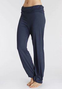 Marineblaue, leichte Stoffhose mit einem weiten, gerafften Bund und lockerem Sitz, versehen mit einem geknoteten Detail am Knöchel.