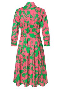 Kwiatowa sukienka w kolorach różowym i zielonym, z kołnierzykiem, długimi rękawami, paskiem w talii, plisowanym dołem i wyraźnym abstrakcyjnym wzorem.
