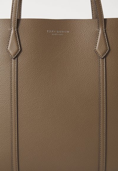 Pruun tekstuuriga nahast kott kahe vertikaalse käepidemega. Peal on reljeeftehnika abil väljatrükitud "TORY BURCH NEW YORK" hõbedane logo.