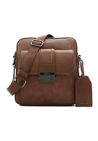 Borsa a tracolla in pelle marrone con finitura testurizzata, dotata di chiusura con patta magnetica, tracolla regolabile e etichetta per bagagli.