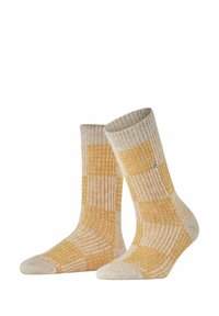 Gelbe und beige gemusterte Socken mit einem gerippten Design, das eine verstärkte Zehe und Ferse aufweist. Das Material hat ein gemütliches, strukturiertes Aussehen.