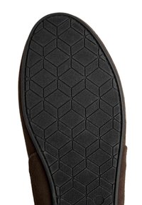 Sole di scarpa in gomma nera con un motivo esagonale, con un bordo superiore marrone visibile, che offre aderenza e durata.