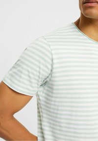 Stribet t-shirt i lys grøn og hvid, korte ærmer, rund halsudskæring, glat tekstur med skiftende vandrette striber.