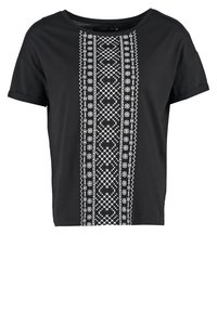Sort t-shirt med korte ærmer, der har et hvidt geometrisk broderet mønster i midten, rund halsudskæring og en afslappet pasform.