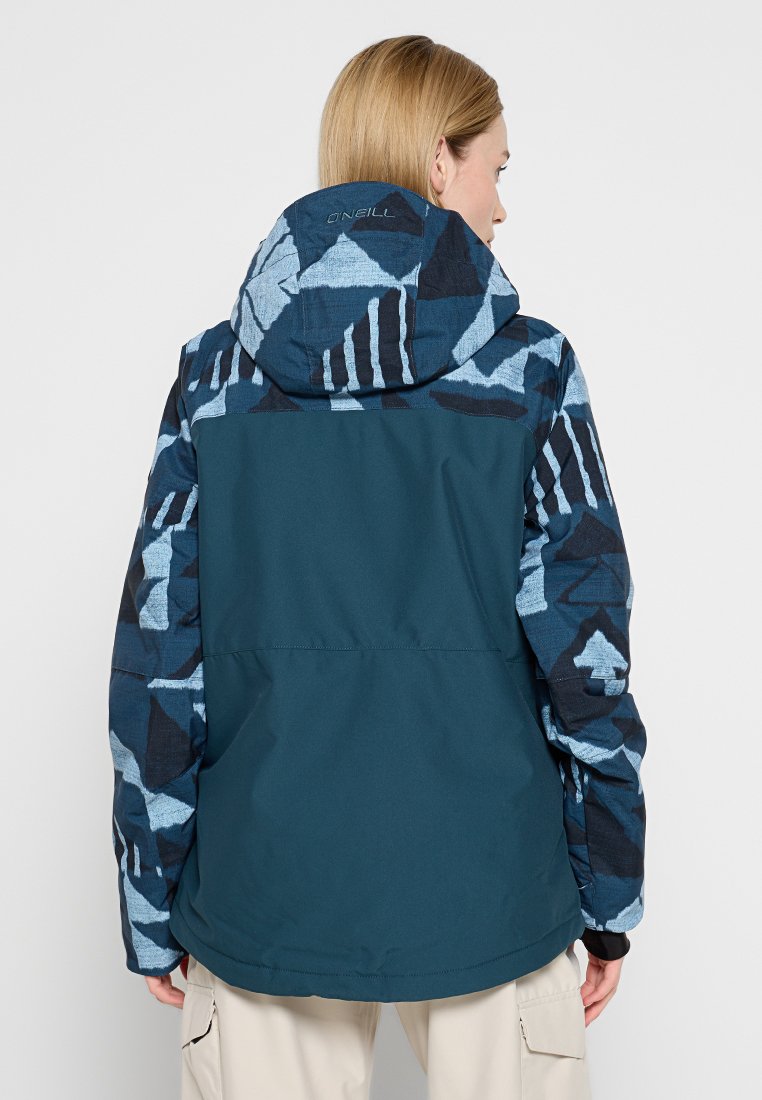 Wasserabweisende Jacke in dunklem Türkis mit blauen geometrischen Mustern an den Ärmeln und der Kapuze. Verfügt über eine Kapuze, elastische Bündchen und einen lockeren Schnitt.