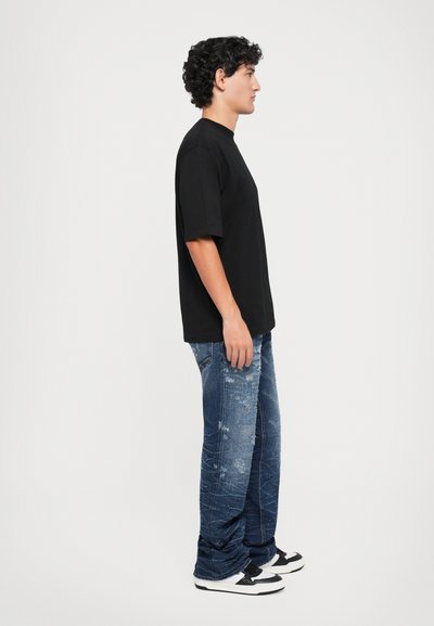 Tricou negru cu mânecă scurtă, croială lejeră, combinat cu blugi albaștri deteriorați. Tenisi cu accente negre și albe completează ținuta.