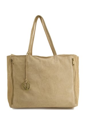 Beige Wildleder-Tote mit doppelten Seitenreißverschlüssen und einem runden Metallanhänger. Verfügt über zwei lange, flache Griffe für ein einfaches Tragen.
