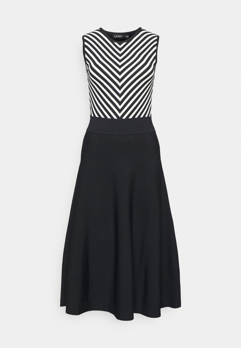 Svart klänning med ärmlös bodice som har vita chevronränder och en figursydd midja, vilket leder till en utsvängd kjol som når till knäna.