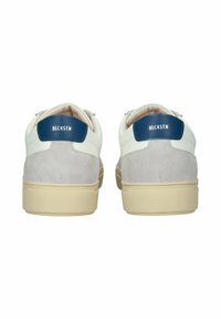 Baskets blanches et grises en matière de daim et de cuir, semelle en caoutchouc beige, avec des accents bleus au niveau du talon affichant le texte "BLCKSTN."