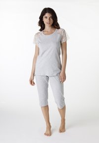 Completo pigiama grigio con top a maniche corte caratterizzato da inserti in pizzo e pantaloni corti. Realizzato in tessuto morbido e leggero.
