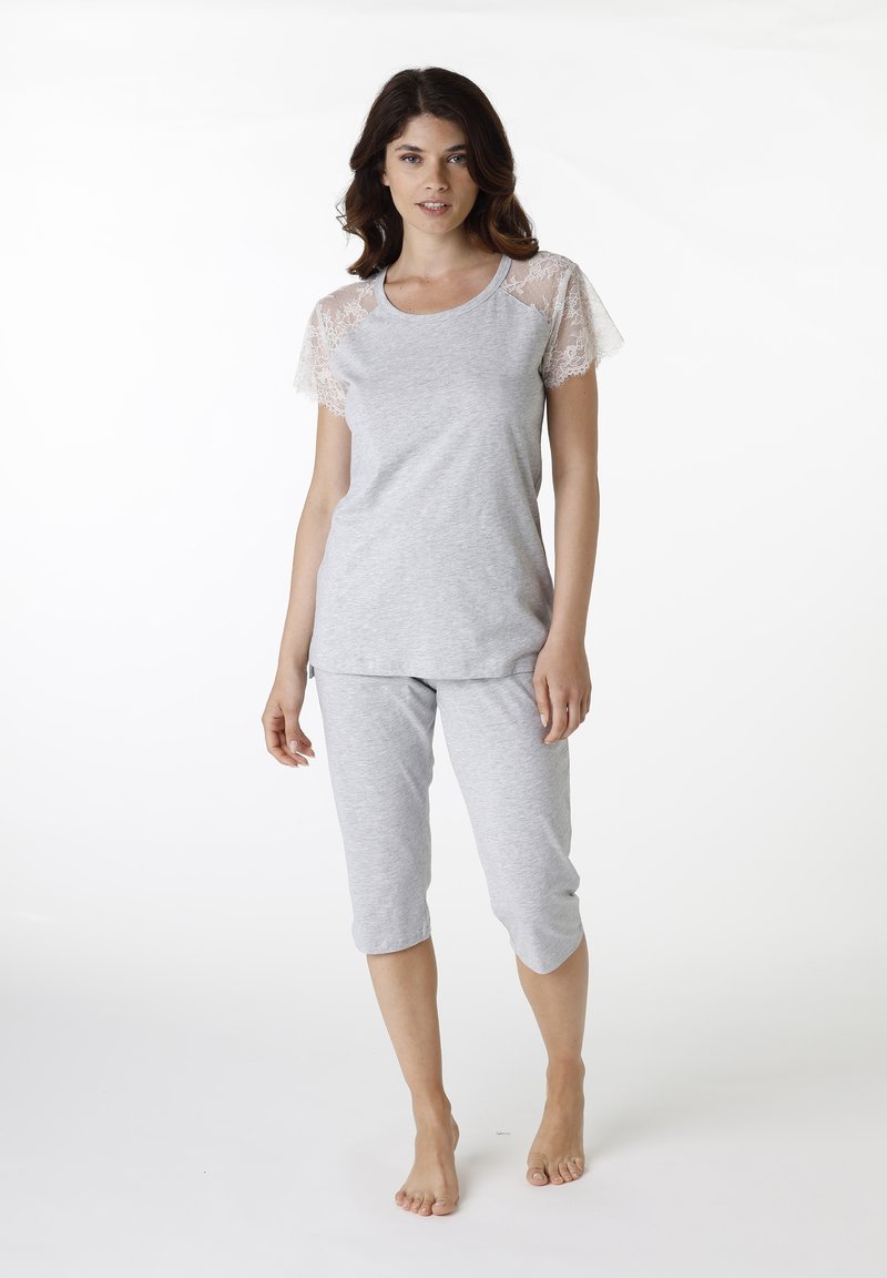 Completo pigiama grigio con top a maniche corte caratterizzato da inserti in pizzo e pantaloni corti. Realizzato in tessuto morbido e leggero.