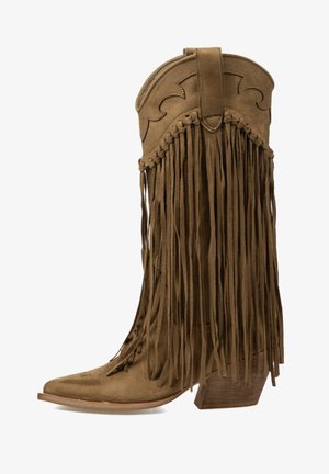 Bota cowboy de ante marrón con detalles de flecos largos, costuras decorativas y un tacón de madera apilado y angulado.