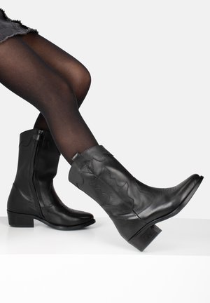 Stivali da cowboy in pelle nera con punte appuntite, cerniera laterale e motivi decorativi in rilievo. Tacco basso a blocco e texture liscia.