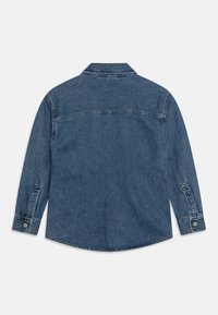 Denim shirt with long sleeves, blue wash, classic collar, and button cuffs. Features a rounded hem and back yoke seam detail.