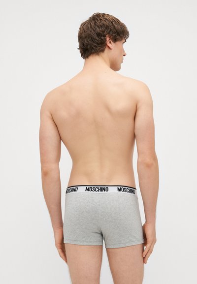 Boxers cinza com uma faixa na cintura preta da Moschino, apresentando um ajuste justo e textura suave, vistos de trás.