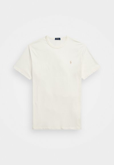 Kortärmad t-shirt med rund hals i off-white bomull. Har en liten broderad logotyp i beige på vänster bröst. Slät textur.