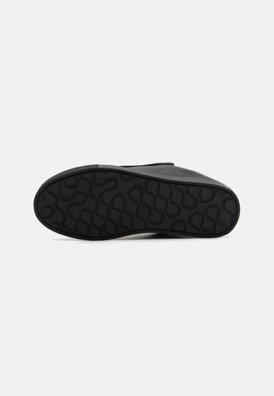 Sort sneakersål med et struktureret grebmønster, der har en glat overdel og rund tådesign. Blød gummibygning for holdbarhed.