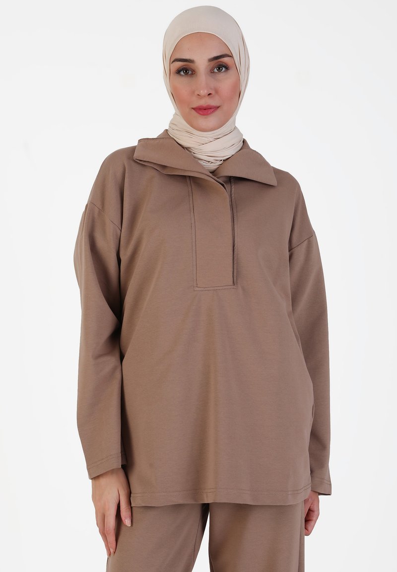 Bruine lange mouw top met een polo kraag en een rechthoekige knopenrij, gemaakt van zachte stof met een gladde textuur.
