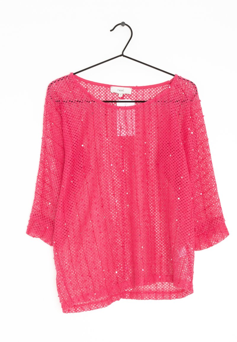Top in rete rosa con maniche a tre quarti, caratterizzato da una vestibilità ampia e sottili accenti di paillettes. Appeso a un gancio nero su uno sfondo bianco.