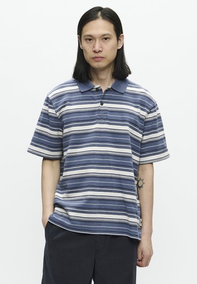 Polo rayé avec des rayures horizontales bleues et blanches, manches courtes, un col à boutons et une étiquette de logo sur le côté. Tissu texturé.