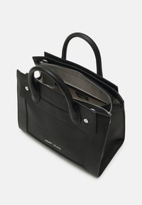 Czarna skórzana torba tote z podwójnymi uchwytami, zapięciem na zamek i srebrnymi detalami. Charakteryzuje się teksturowaną powierzchnią i wnętrzem z przegrodami.