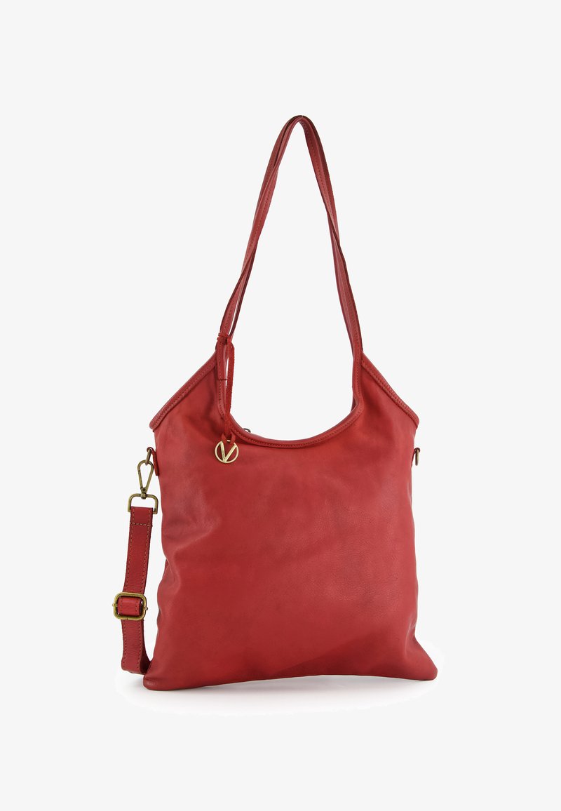 Red leather tote bag with two long straps, a zip closure, and a gold logo accent. Smooth texture and minimalist shape. Adjustable shoulder strap.