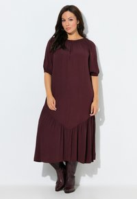 Lange maroon jurk met korte pofmouwen, een geplooide halslijn en een uitlopende zoom met een geplooid ontwerp en gelaagde textuur.